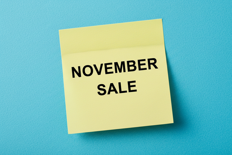 create an image with the phrase "NOVEMBER SALE" and show it on a blue background it should be written on a yellow sticky note